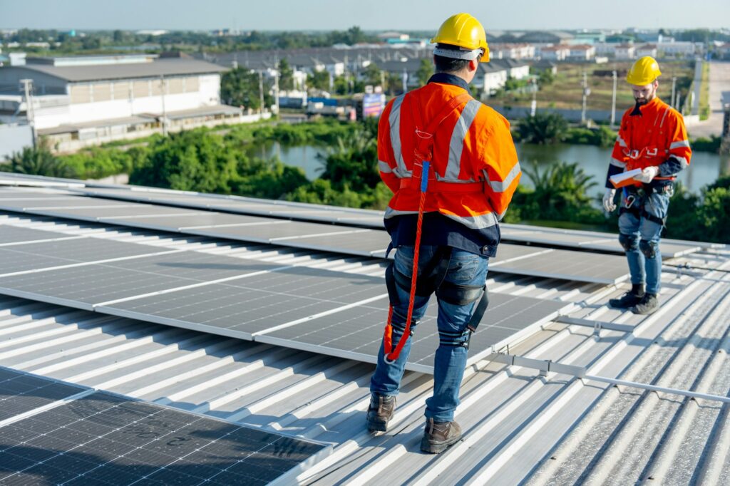 Back of technician worker stand and discuss about installation and maintenance the solar cell panels